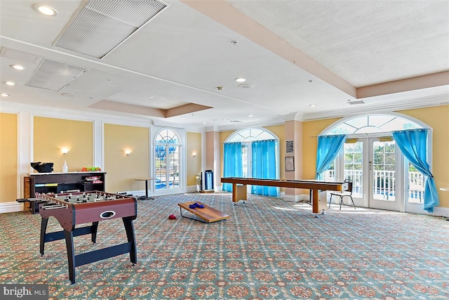 game room featuring carpet flooring, french doors, ornamental molding, and a raised ceiling