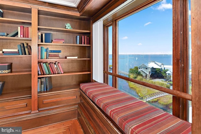 living area featuring a water view and crown molding