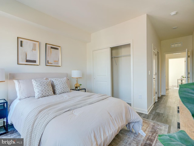 bedroom with wood-type flooring and a closet