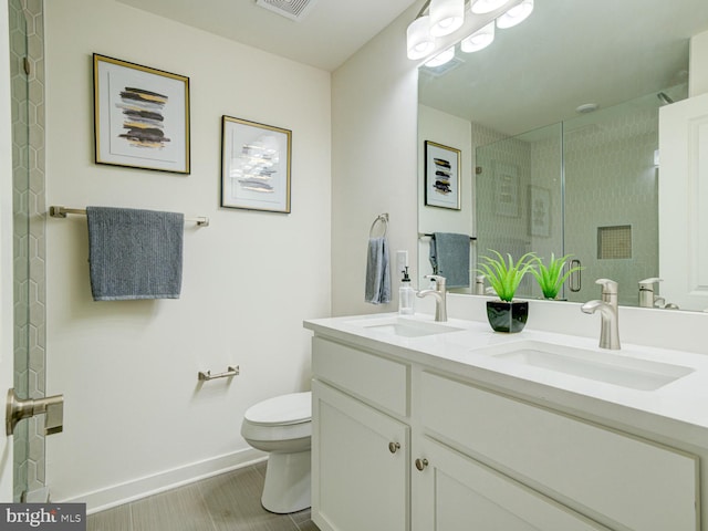 bathroom featuring vanity, tiled shower, and toilet