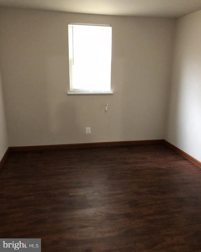 spare room featuring dark wood-type flooring