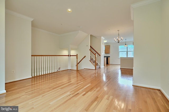 unfurnished room featuring ornamental molding, light hardwood / wood-style flooring, and a chandelier