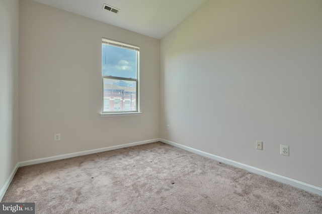 empty room featuring lofted ceiling and light colored carpet