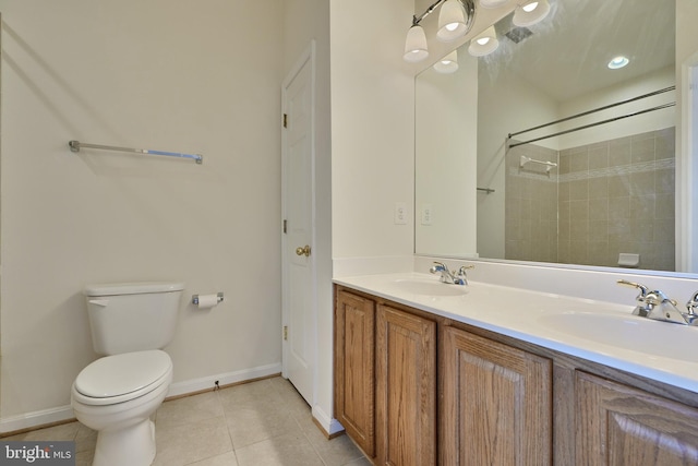 bathroom featuring toilet, vanity, tile patterned floors, and tiled shower