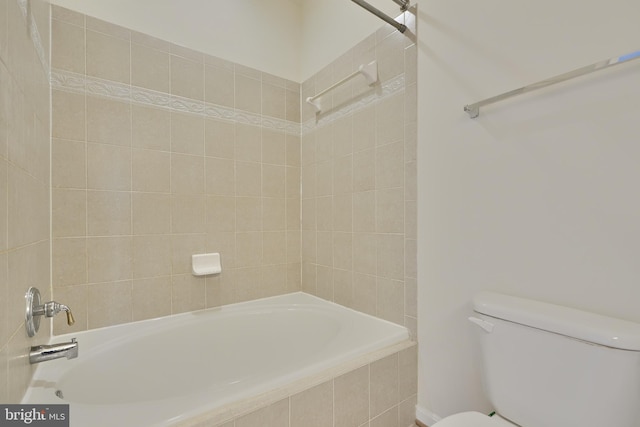 bathroom featuring tiled shower / bath combo and toilet