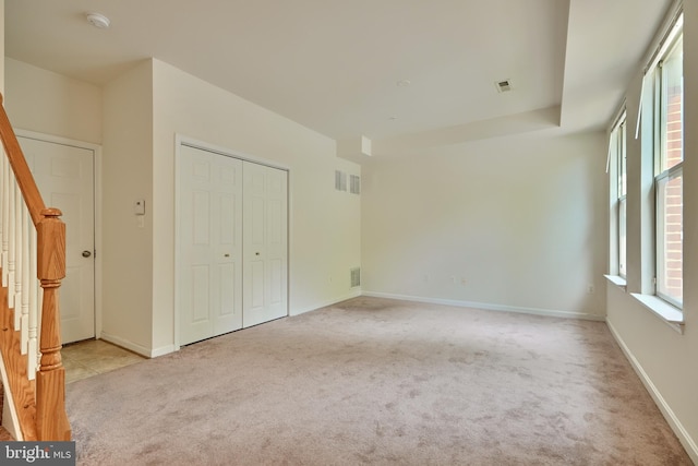 unfurnished bedroom with a closet and light colored carpet