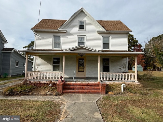 view of front of house with a front yard and a porch