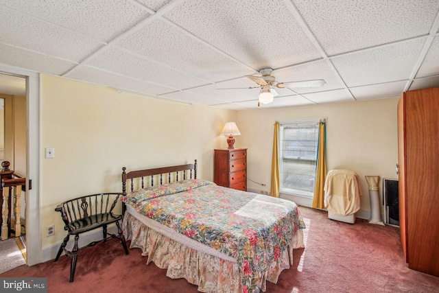 bedroom featuring ceiling fan, a paneled ceiling, and carpet flooring