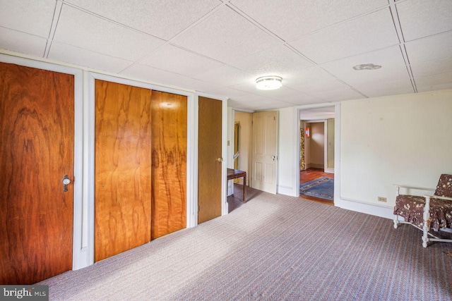 interior space with multiple closets, a paneled ceiling, and carpet floors