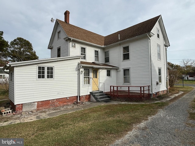 back of house featuring a deck and a yard