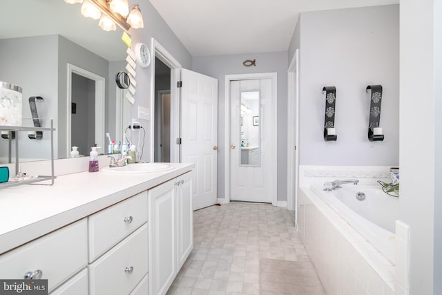 bathroom featuring vanity and a relaxing tiled tub