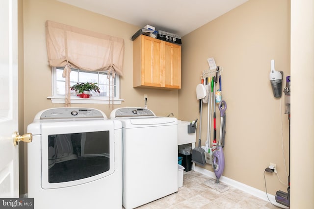 laundry room with washing machine and clothes dryer and cabinets