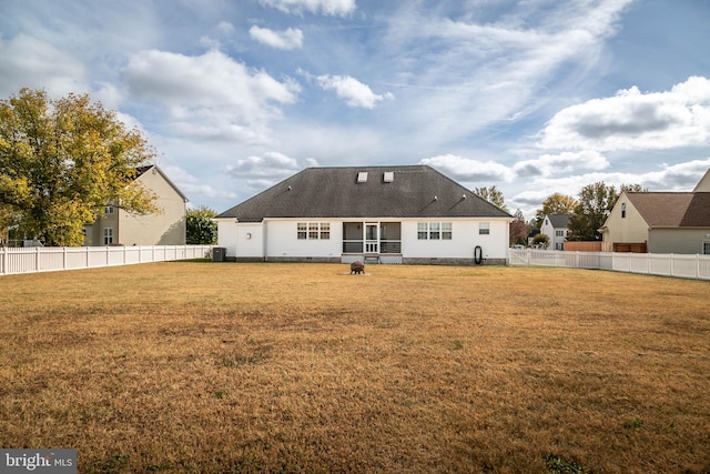 back of house featuring central AC and a yard