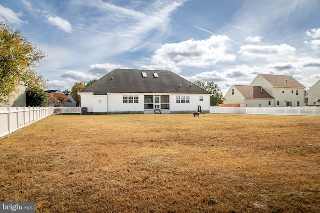 rear view of house featuring a yard and central air condition unit