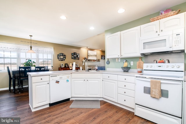 kitchen featuring white appliances, white cabinets, sink, dark hardwood / wood-style flooring, and kitchen peninsula