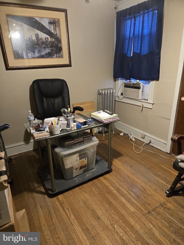 office space featuring hardwood / wood-style floors, radiator, and cooling unit