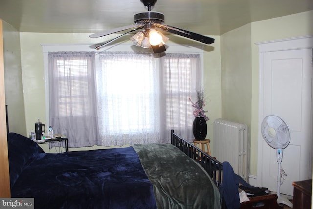 bedroom with ceiling fan and radiator