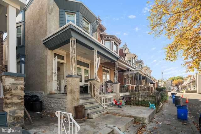 rear view of property featuring covered porch