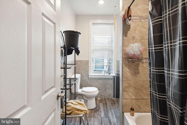 bathroom with shower / bath combo, wood-type flooring, toilet, and tile walls