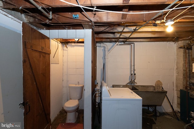 basement featuring sink and washer / dryer