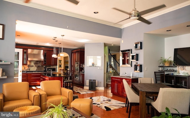 living room with ornamental molding, light hardwood / wood-style floors, and ceiling fan