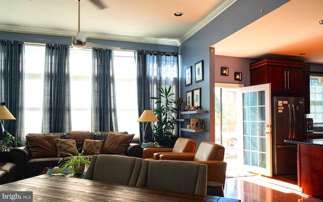 living room featuring hardwood / wood-style flooring, a healthy amount of sunlight, and crown molding