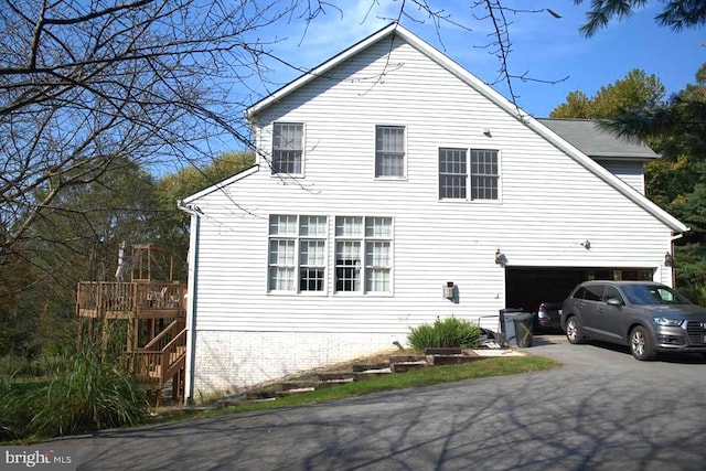 view of side of property with a garage and a wooden deck