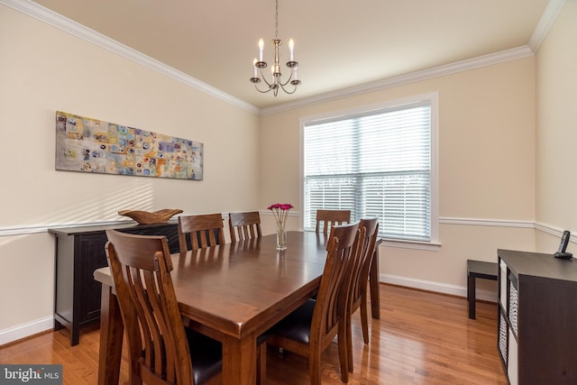 dining area with an inviting chandelier, light hardwood / wood-style flooring, and crown molding