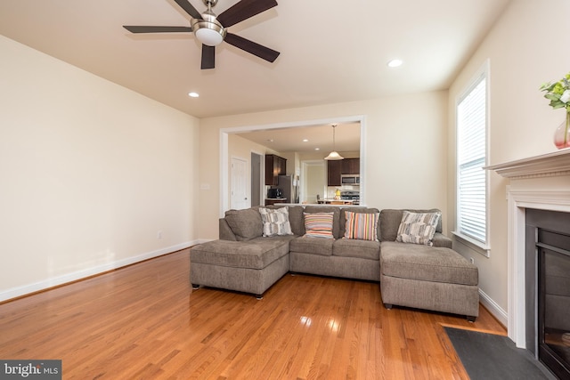 living room with hardwood / wood-style floors, ceiling fan, and plenty of natural light