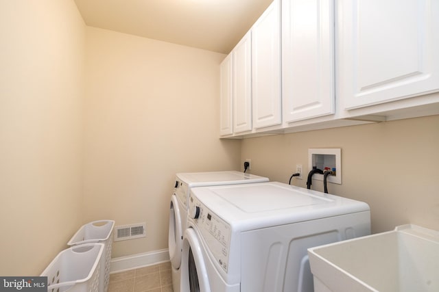 washroom featuring cabinets, sink, and independent washer and dryer