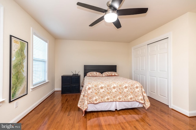 bedroom featuring hardwood / wood-style floors, ceiling fan, and a closet