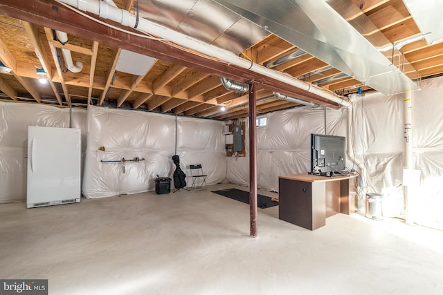 basement with electric panel and white fridge