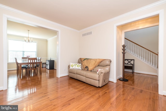 living room with hardwood / wood-style floors, a notable chandelier, and ornamental molding