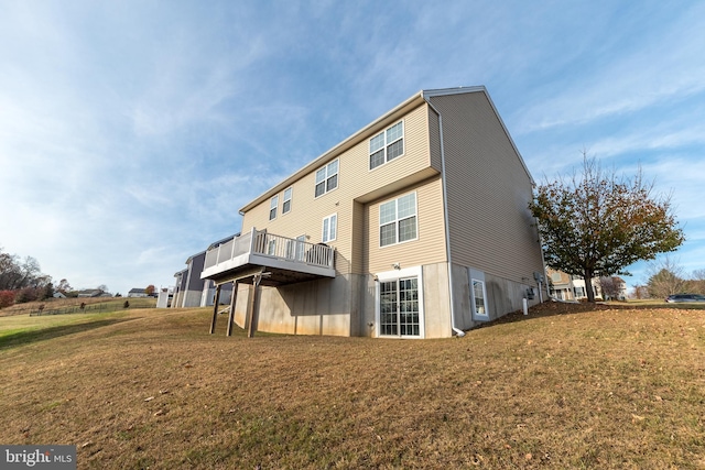 rear view of house featuring a lawn and a wooden deck