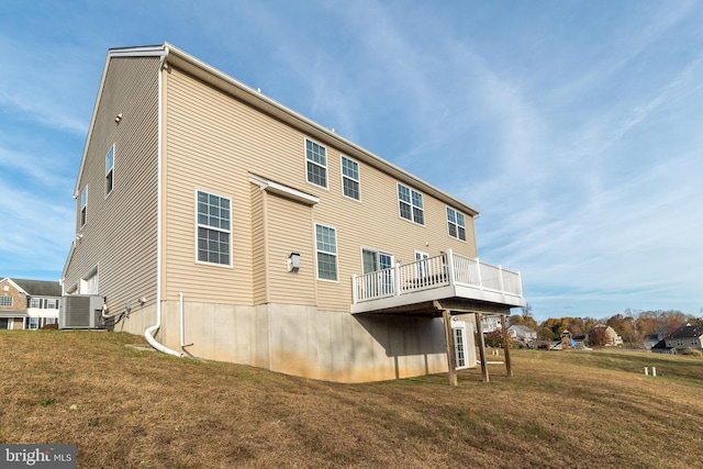 rear view of house featuring central air condition unit, a yard, and a deck