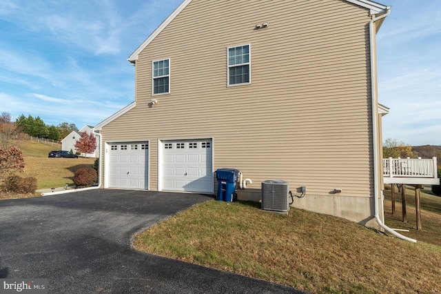 view of side of property featuring central AC unit, a garage, a yard, and a deck