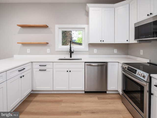 kitchen featuring sink, white cabinetry, light hardwood / wood-style flooring, and appliances with stainless steel finishes