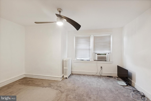 carpeted spare room featuring ceiling fan, cooling unit, and radiator heating unit