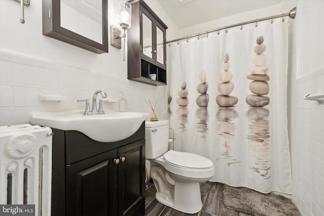 bathroom with hardwood / wood-style flooring, tile walls, toilet, vanity, and a shower with shower curtain