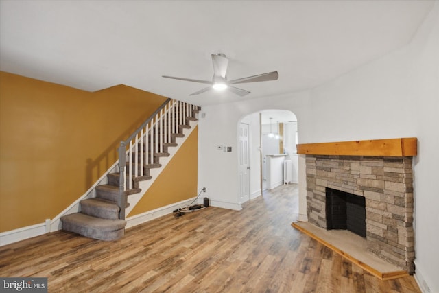 unfurnished living room with ceiling fan, a fireplace, and hardwood / wood-style floors