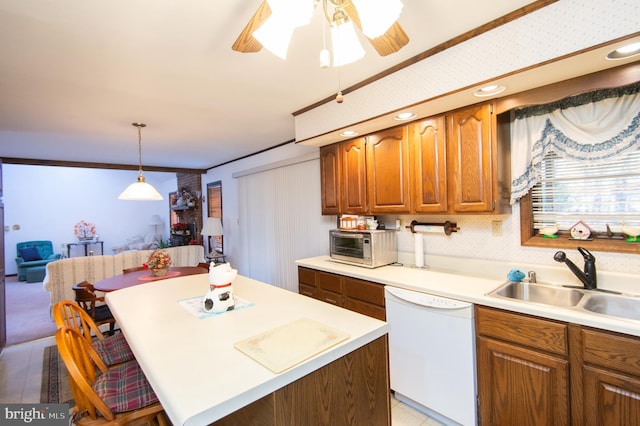 kitchen featuring dishwasher, a kitchen breakfast bar, crown molding, sink, and hanging light fixtures