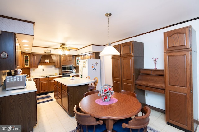 kitchen featuring custom range hood, stainless steel appliances, ceiling fan, decorative light fixtures, and a center island