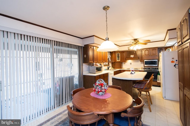 dining space with light tile patterned flooring, ceiling fan, and sink