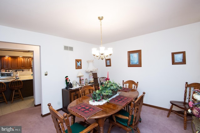 dining space with light carpet and an inviting chandelier