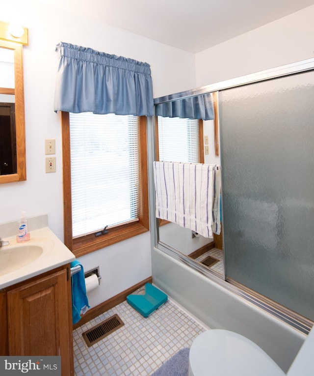 full bathroom featuring tile patterned flooring, vanity, enclosed tub / shower combo, and toilet