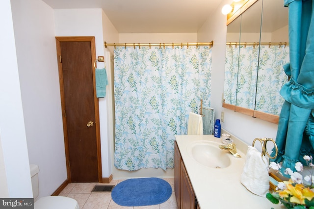 bathroom featuring tile patterned flooring, vanity, and toilet