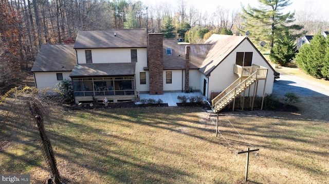 rear view of property with a sunroom, a yard, and a patio