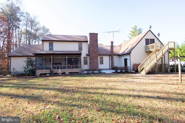 back of house with a lawn and a sunroom