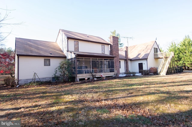 back of property featuring a sunroom and a yard