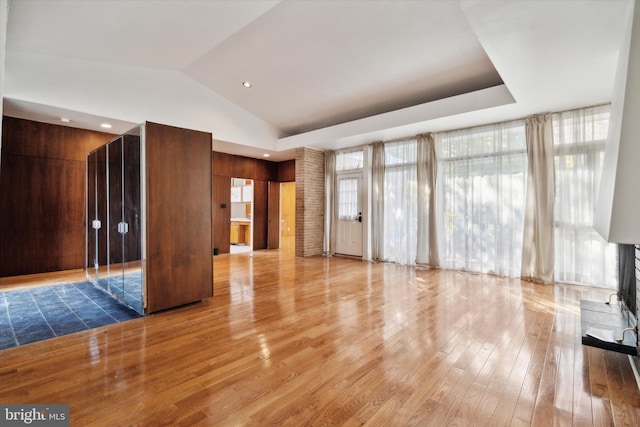 unfurnished living room featuring hardwood / wood-style floors and vaulted ceiling